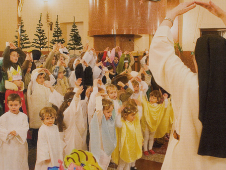 Ordensschwester übt mit Kindern ein Krippenspiel ein